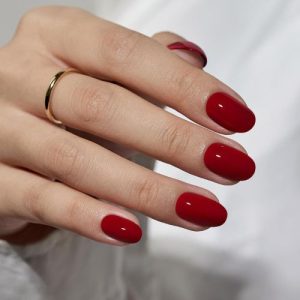 Short red press-on nails with an oval shape, packaged with nail glue, featuring 16 sizes for a perfect fit, ideal for fall, Valentine's Day, or everyday use.